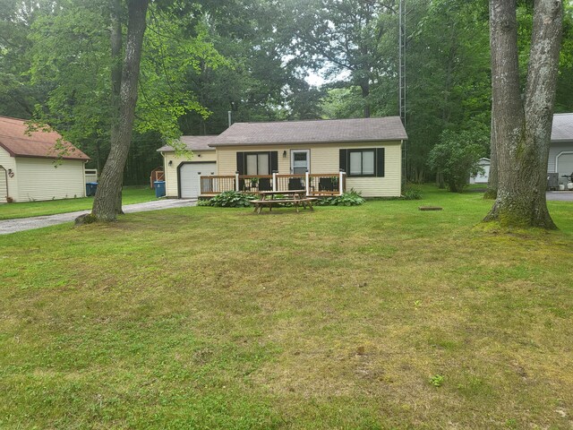 single story home with a garage, an outdoor structure, a deck, and a front lawn