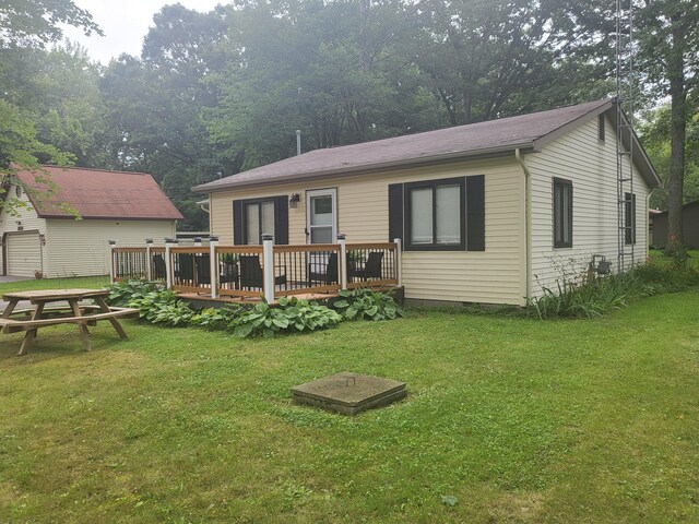 rear view of house featuring a deck and a lawn