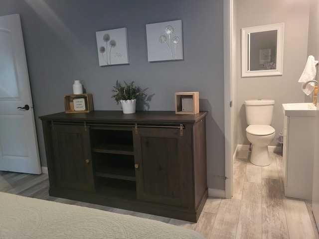 bathroom featuring wood-type flooring, toilet, and vanity