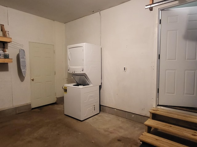 interior space featuring stacked washing maching and dryer and concrete flooring