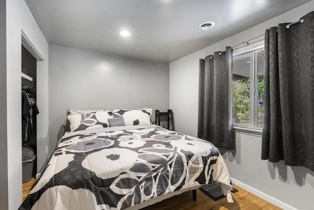 bedroom featuring baseboards, visible vents, wood finished floors, a closet, and recessed lighting