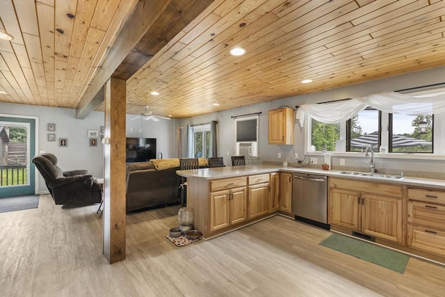 kitchen featuring dishwasher, open floor plan, light countertops, light wood-type flooring, and a sink