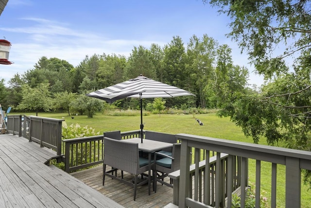 deck with outdoor dining space and a lawn