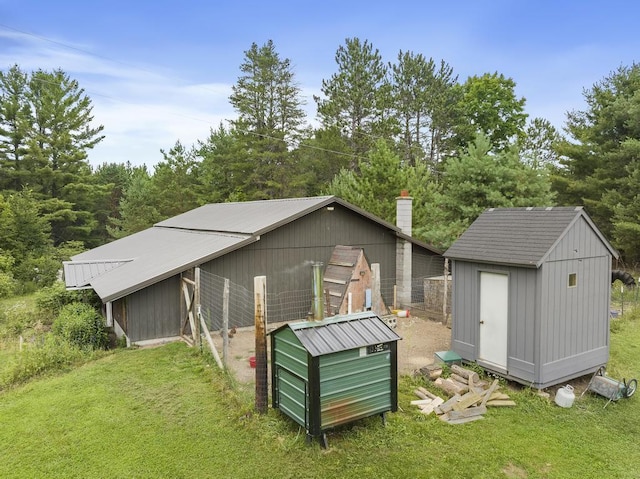 back of property featuring a yard, metal roof, and an outdoor structure