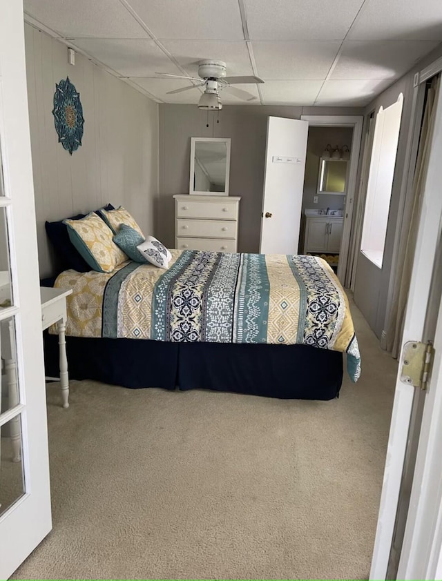 carpeted bedroom featuring a drop ceiling and ceiling fan