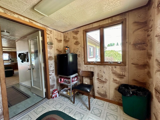 interior space with wooden walls and light tile patterned floors