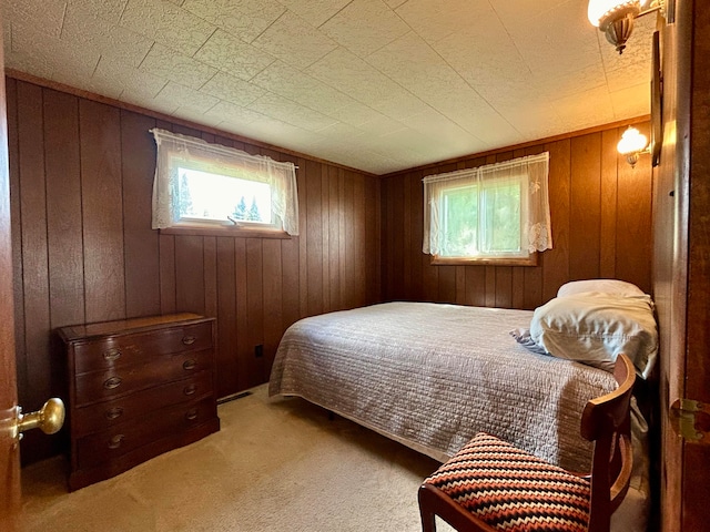 bedroom with wood walls and carpet