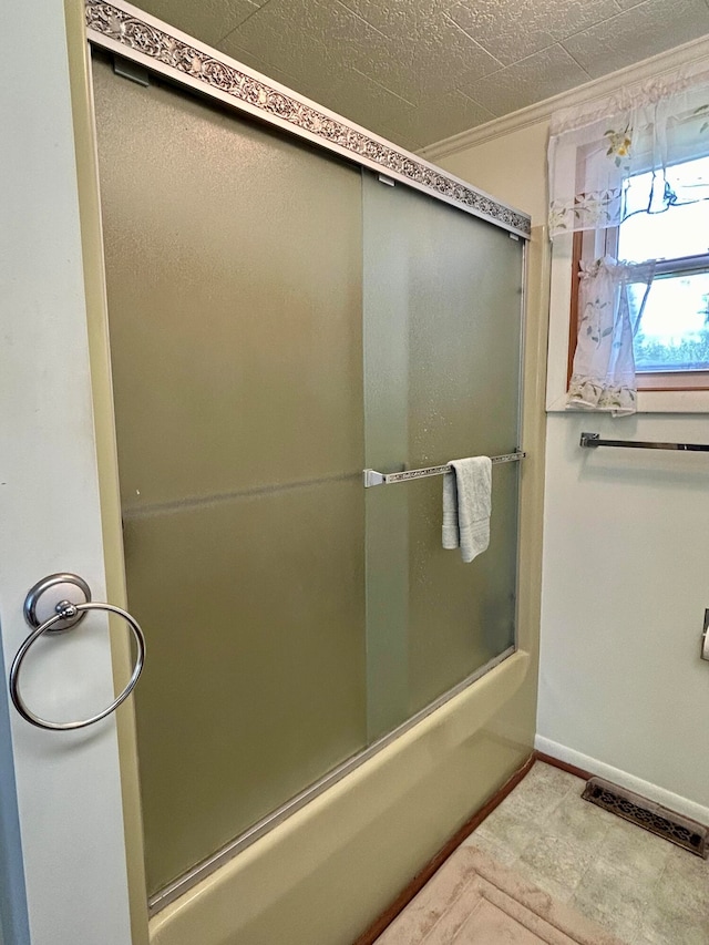 bathroom featuring shower / bath combination with glass door and tile patterned floors