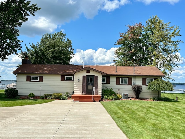 ranch-style home with central AC unit and a front yard