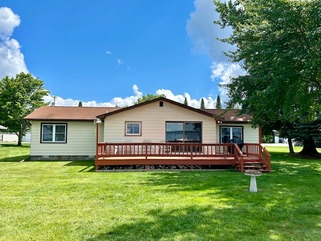 rear view of property featuring a deck and a lawn