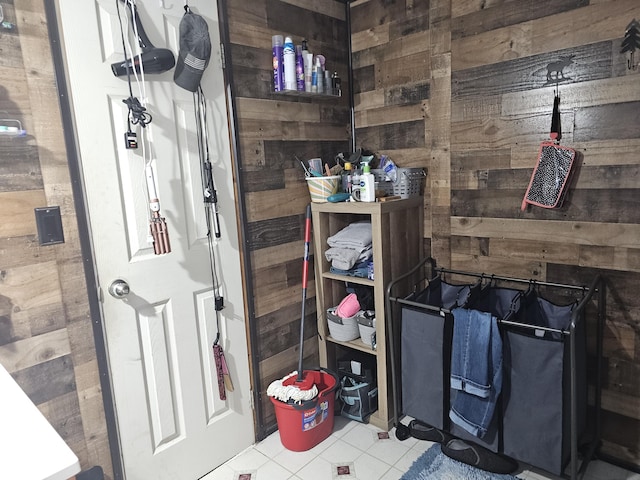 bathroom featuring tile patterned flooring and wood walls