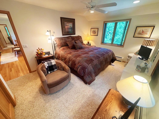 bedroom featuring a ceiling fan, a baseboard radiator, baseboards, and wood finished floors