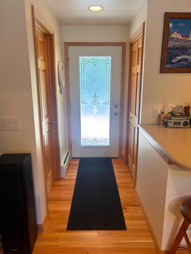 doorway featuring a baseboard radiator, light wood-style flooring, baseboards, and recessed lighting