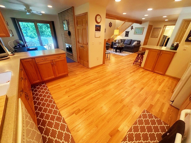 kitchen featuring a peninsula, light wood finished floors, and light countertops