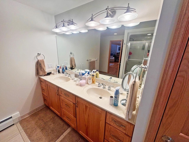 bathroom featuring a baseboard heating unit, a stall shower, a sink, and double vanity