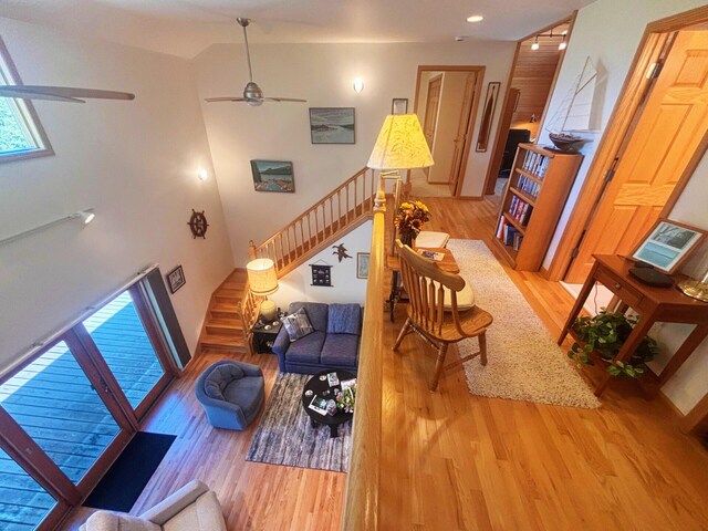 living room with a ceiling fan, stairway, and wood finished floors