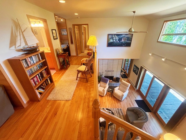 living room with recessed lighting, a brick fireplace, and light wood-style flooring