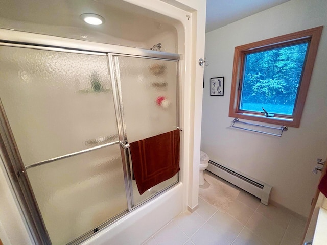 bathroom with a baseboard heating unit, tile patterned flooring, toilet, and baseboards