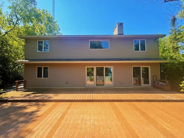 rear view of house with a deck and a chimney