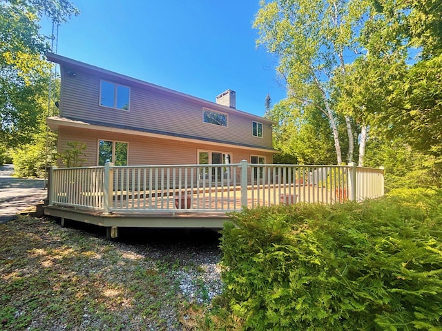 rear view of property with a chimney and a wooden deck