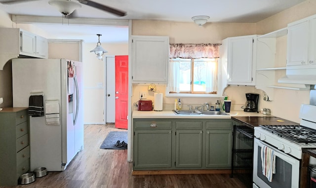 kitchen with white cabinets, dark hardwood / wood-style flooring, sink, decorative light fixtures, and white appliances