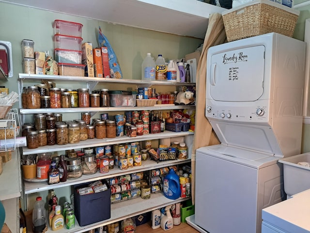 laundry room with wood-type flooring and stacked washer and clothes dryer