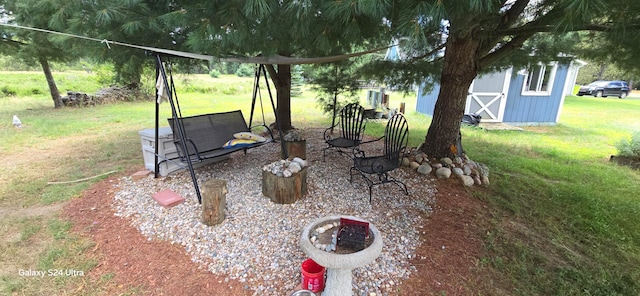 view of yard featuring an outdoor fire pit and an outbuilding