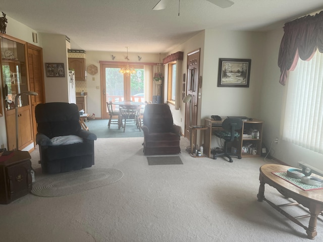 living room featuring ceiling fan with notable chandelier and carpet floors