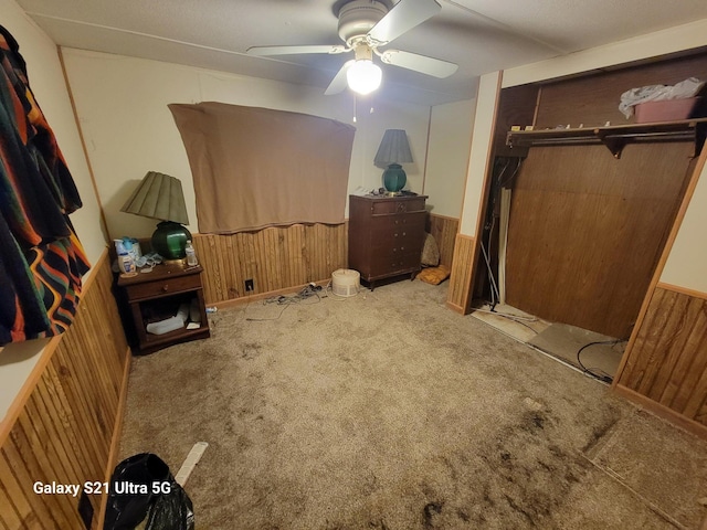 carpeted bedroom featuring ceiling fan and a closet