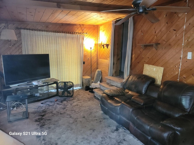 carpeted living room featuring wooden ceiling, wooden walls, beam ceiling, and ceiling fan