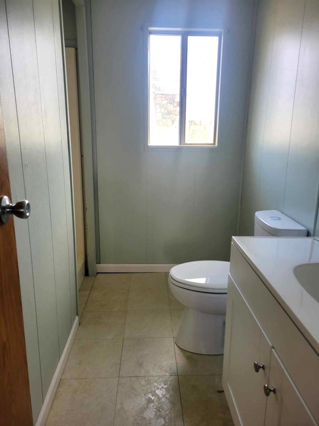 bathroom with toilet, vanity, and tile patterned floors