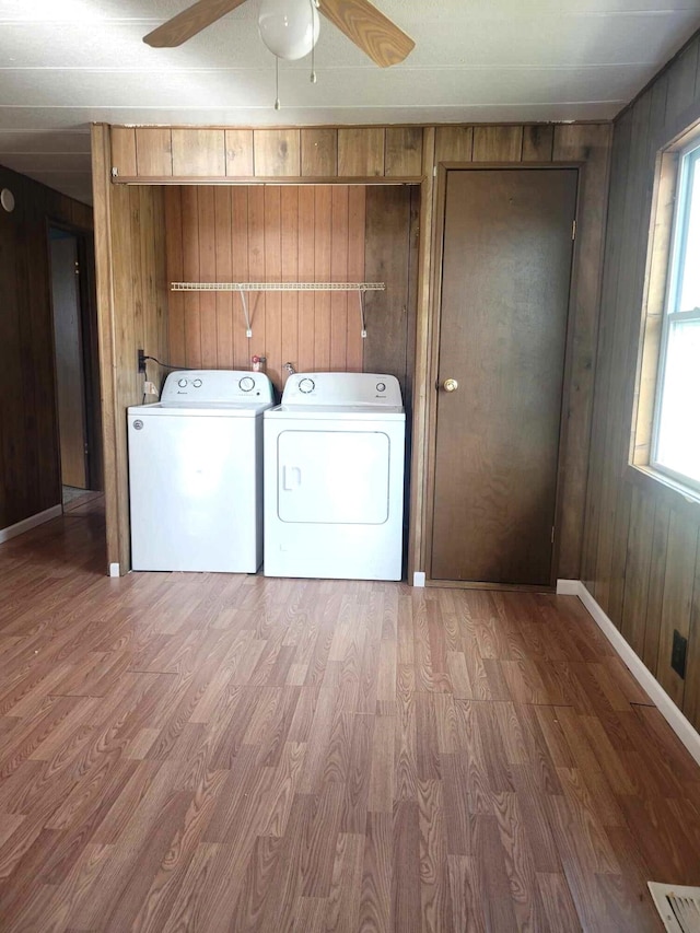 laundry area featuring wood walls, wood-type flooring, and ceiling fan