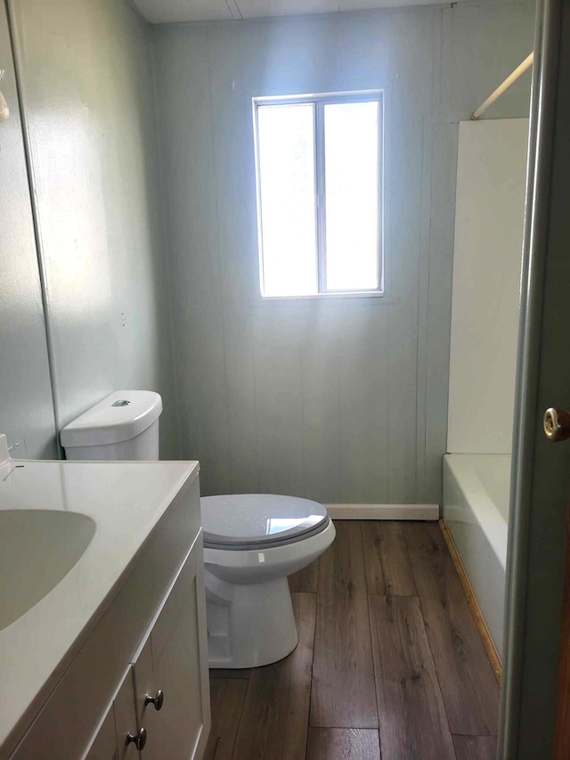 full bathroom featuring shower / bathing tub combination, vanity, hardwood / wood-style flooring, and toilet