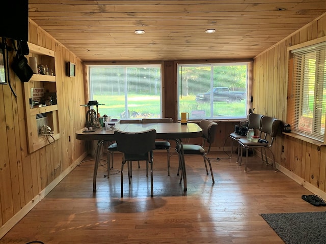 office with wooden walls, built in shelves, wood ceiling, and hardwood / wood-style flooring