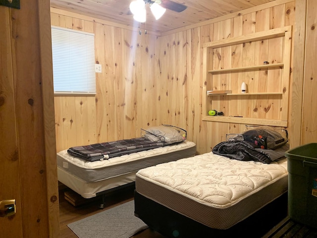 bedroom with wooden ceiling, wooden walls, and ceiling fan