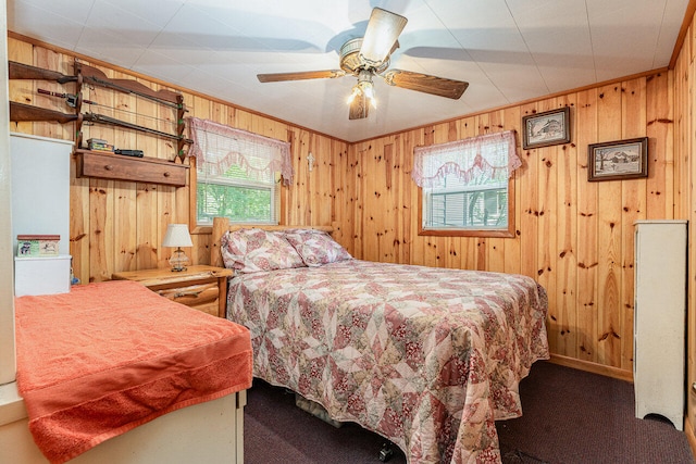 carpeted bedroom featuring ceiling fan and wooden walls