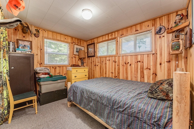 bedroom featuring wooden walls and carpet