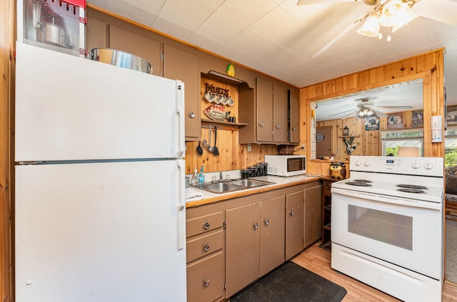 kitchen with light wood-type flooring, white appliances, sink, and ceiling fan