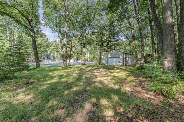 view of yard featuring a garage and an outbuilding