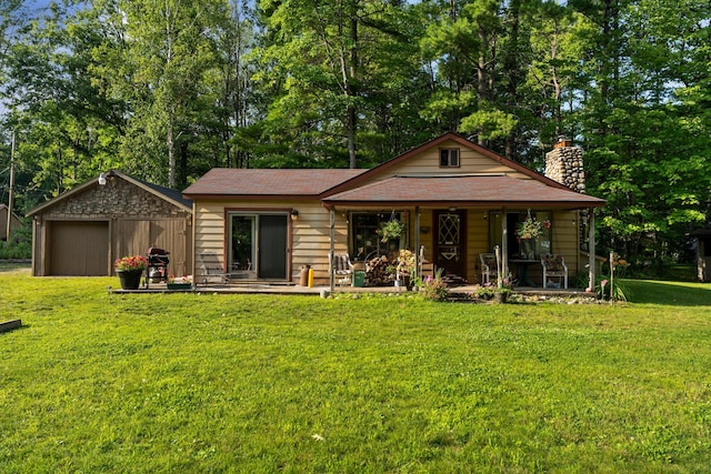 view of front of house with an outdoor structure and a front yard