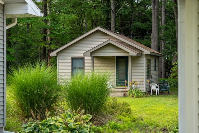 bungalow-style home with a front yard and an outbuilding