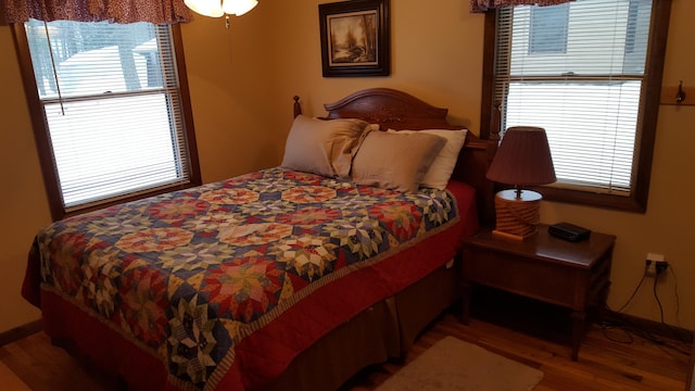 bedroom featuring multiple windows and hardwood / wood-style flooring