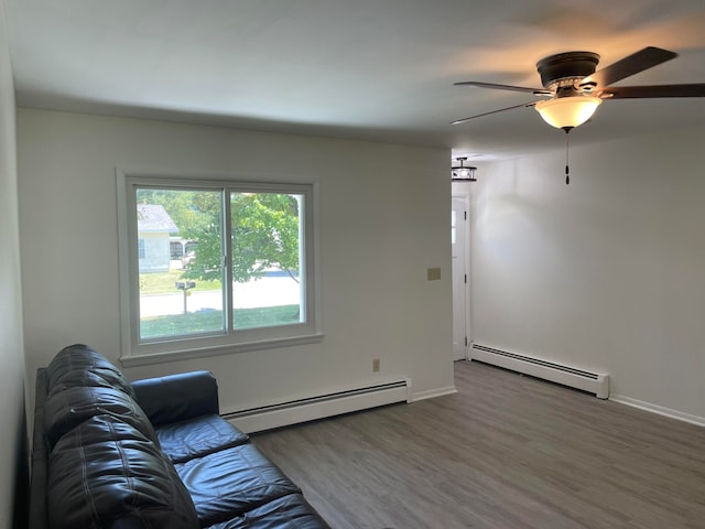 living room with ceiling fan, a baseboard heating unit, and hardwood / wood-style flooring