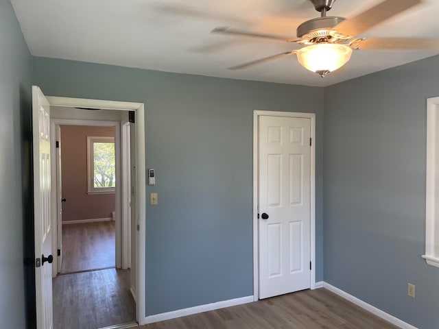 unfurnished bedroom featuring ceiling fan, hardwood / wood-style flooring, and a closet