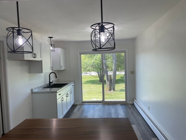 kitchen featuring sink, decorative light fixtures, dark wood-type flooring, baseboard heating, and white cabinets