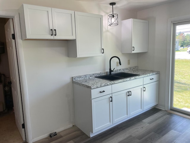 kitchen featuring sink, white cabinetry, pendant lighting, and dark wood-type flooring