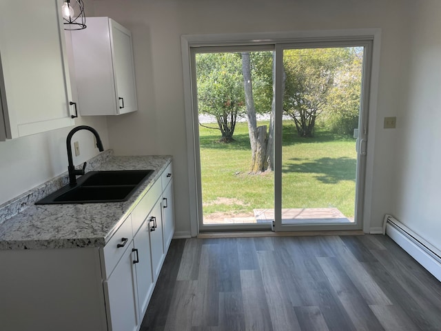 kitchen featuring sink, dark hardwood / wood-style flooring, decorative light fixtures, a baseboard radiator, and white cabinetry