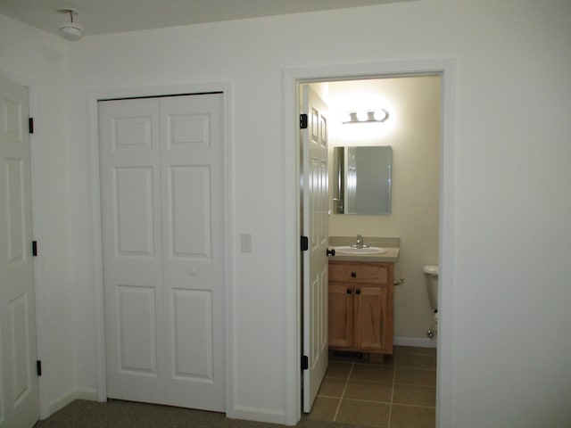 bathroom with toilet, vanity, and tile patterned floors