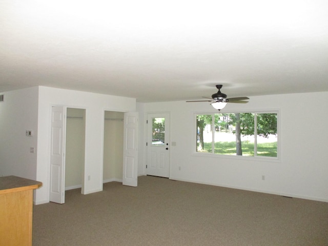 unfurnished living room featuring carpet floors and ceiling fan