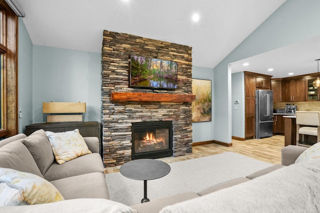 living room with lofted ceiling, a fireplace, and light hardwood / wood-style floors